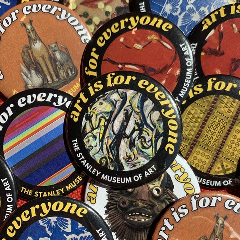 An up-close image of a pile of pinback buttons. Each button reads "art is for everyone" and features an image of a work of art from the Stanley's collection.