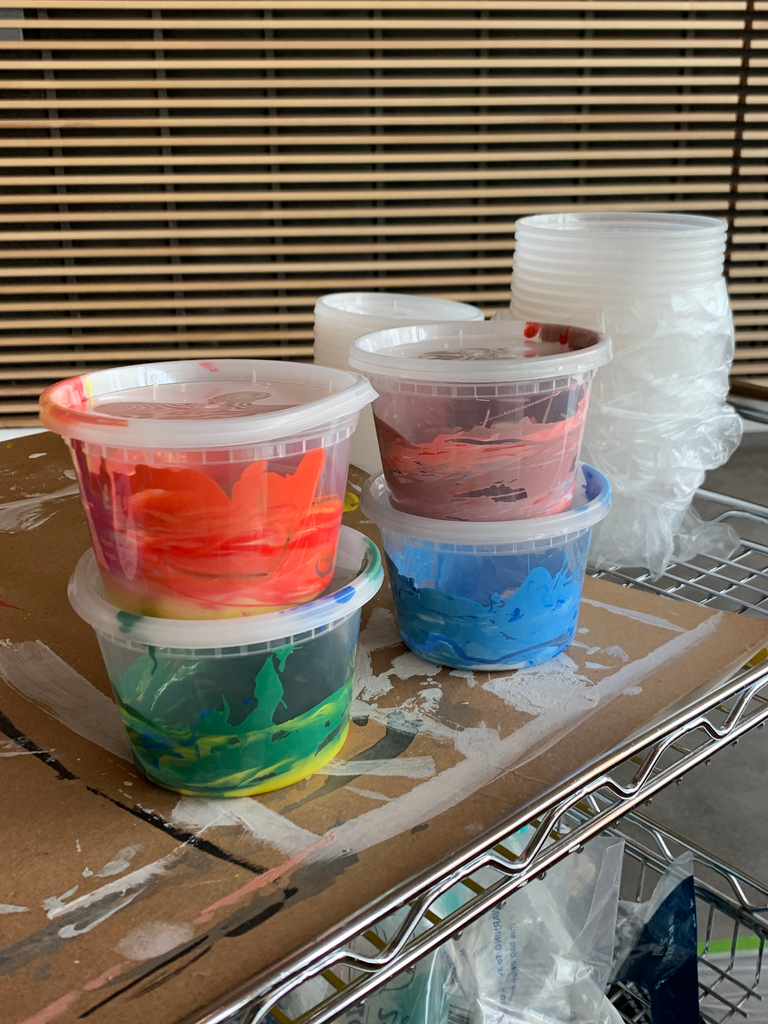 A photo of little plastic containers of ink; there are four of them, two stacks of two. An orangey ink is stacked atop a green ink, and a light pink ink is stacked atop a sky blue.