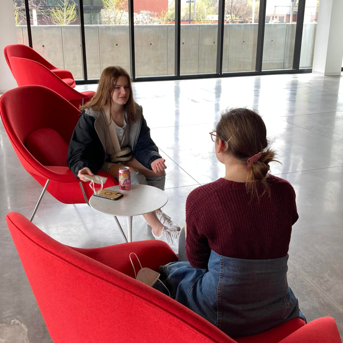 Two students sit together in the Stanley lobby. 